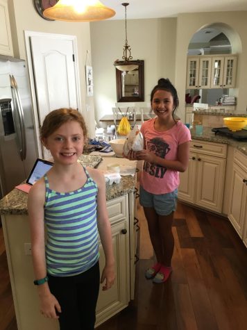 (Above) Kiera Moore and Delaney Bolstein, both age ten, bake cookies during the summer before sixth grade. Kiera sports a neon green tank while Delaney wears a shirt with a hipster cat. They represent the uniqueness of tween fashion while doing what most tweens today would not imagine staying off their phones.