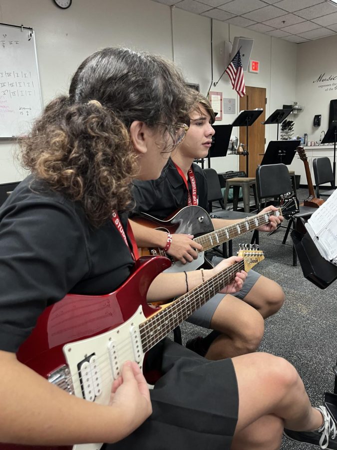 (Above) Elisa Davis, grade 11, teaches
RJ Triozzi, grade 11, how to play a jazz
piece on the guitar. Like many other band
members, RJ knows how to play other
instruments. However, unlike the others,
RJ’s voice is featured on Harlem musician,

Cab Calloway’s song, “Minnie the Mooch-
er.” Photo by Delaney Bolstein.