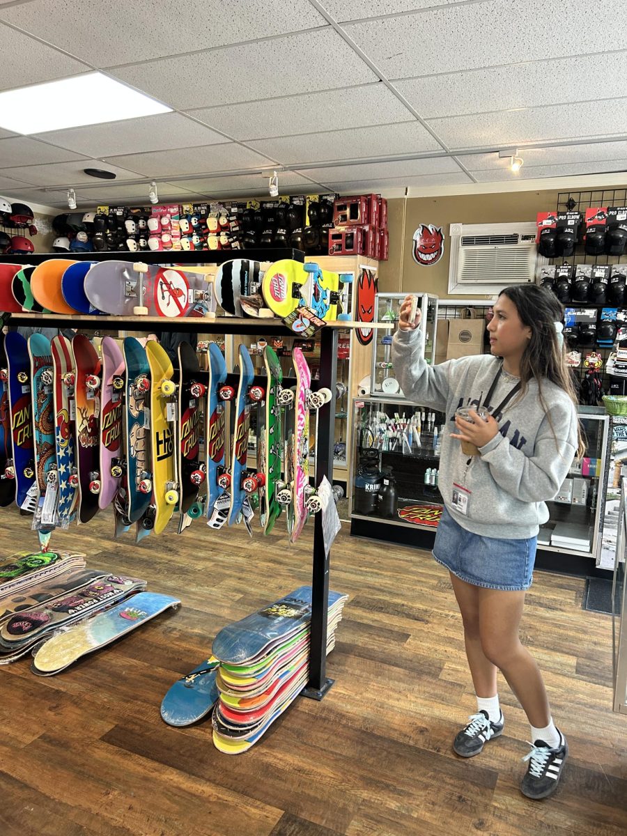 (Above) As human beings, we are often captivated by the beauty of colors and shapes. Walking into Galactic G Skateshop on Orange Ave, a visitor can be met with an explosion of loud graphics, polished boards, and funky designs. Delaney Bolstein, grade 12, pauses to take a quick snapshot of the almost-ornamental display. Undeniably, theres a vibe to this small shop that cant be found in large commercial stores. Its the reachable feeling much like listening in on the two skaters behind the racks fussing over what color wheels would look most ice on their boards. 