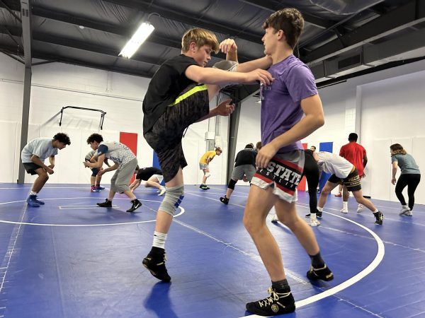 (Above) Charlie De Sena (left) and Zeno Moore (right), both grade 10, are running through one of the drill techniques during practice. Being a wrestler is a lifestyle of dedication and commitment, and it doesn’t come easy. “Traveling, making weight, competing, doing homework at the airport during a delayed flight, getting back Monday morning at 1:00 A.M., and then showing up to school the same day. It’s a grind,” Omer Barak, grade 12 said. Yet, he loves the sport because of the, “Sacrifice it entails, and the dedication…and the hard work you put in shows. There’s no hiding.” This hard-won relationship of devotion is clearly echoed throughout the team. Yes, it’s hard, but that’s exactly what wrestlers love about it. In this spirit, it becomes more than just wrestling. It’s tackling and growing from valuable life lessons. 