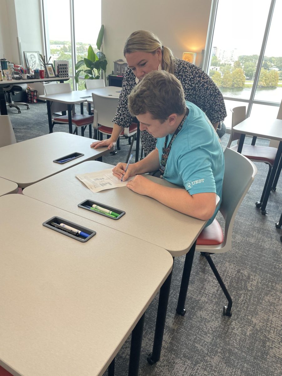 (Above) Marty Hall, grade 12, and Mrs. Chelsea Christensen discuss an AP Seminar worksheet in room P407. AP Seminar involves complex analysis of articles by other authors. 