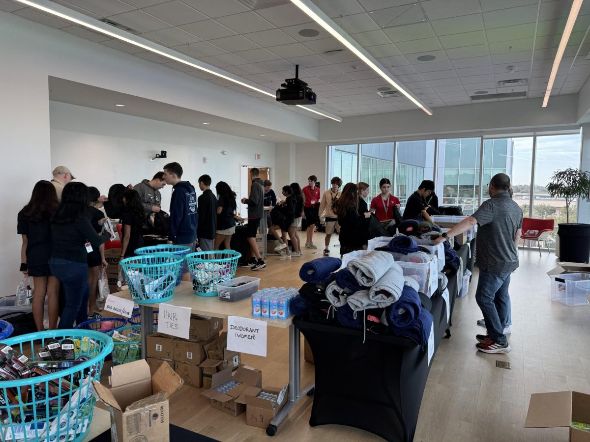 (Above) Once people had their bags filled they would take them to a bag checking station, with the help of teachers Mr. Sharkey and Mrs. Flader, to determine the sizing of the clothes. Clothing items extended from shirts, sweatpants, flip flops, and many other kinds of sizes of clothes. Evan stated, “The event itself was both a huge success and a blast. I enjoyed watching both my fellow teachers and friends compete with each other to see who could fill the most bags out of everyone.” Evan, getting into specific detail, mentioned “Most of the articles of clothing and hygiene products were purchased from Dollar Tree. This was the best place to buy the items and make sure that I had enough.”