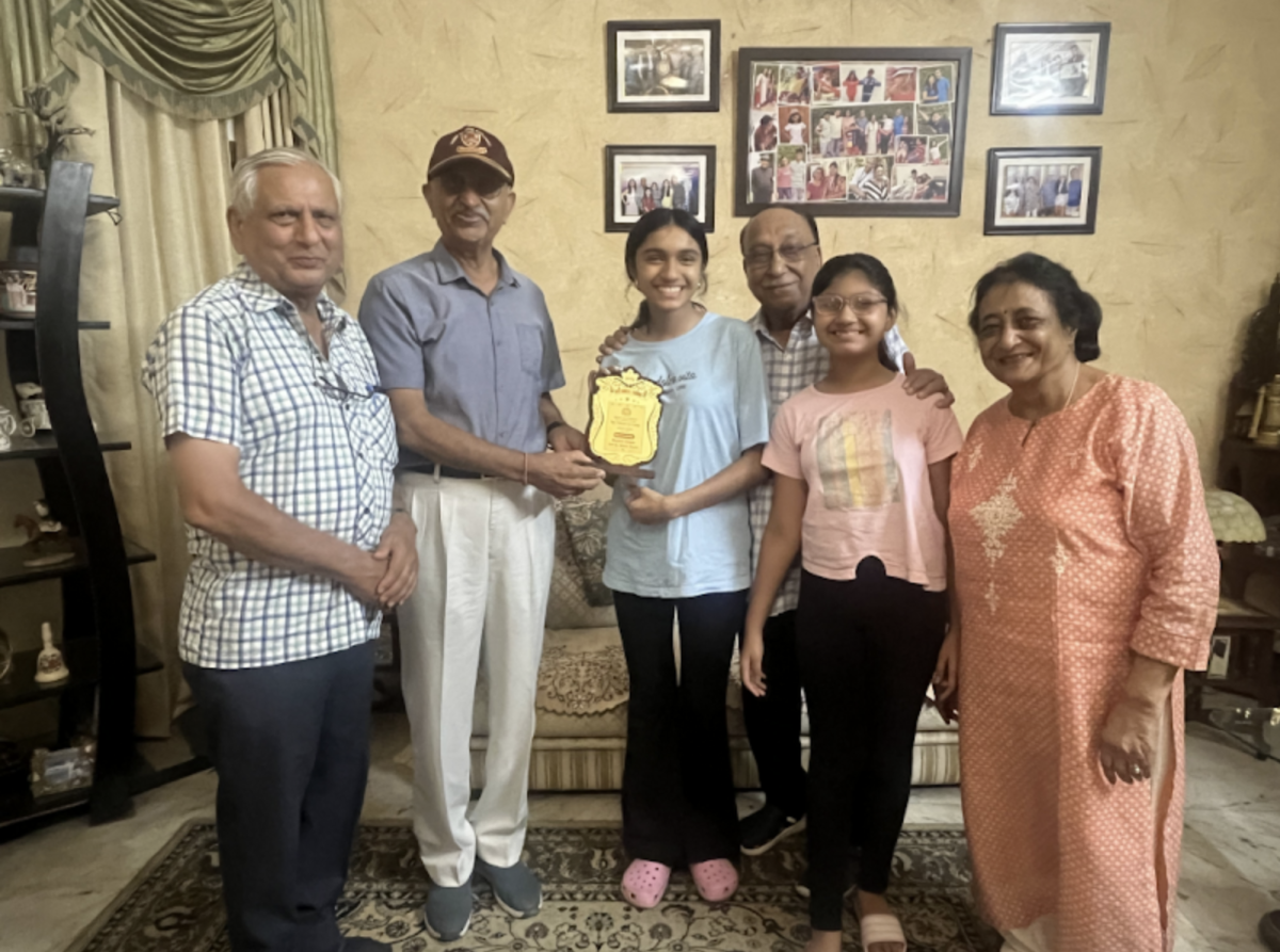 (Above) Kashvi Gupta, grade 9, (center) receives an award from the Bharat Vickas Parishad for her dedication to improving children's eye health in local schools. She provided dozens of students with free eye exams and glasses, so they could see clearly and succeed in classrooms.