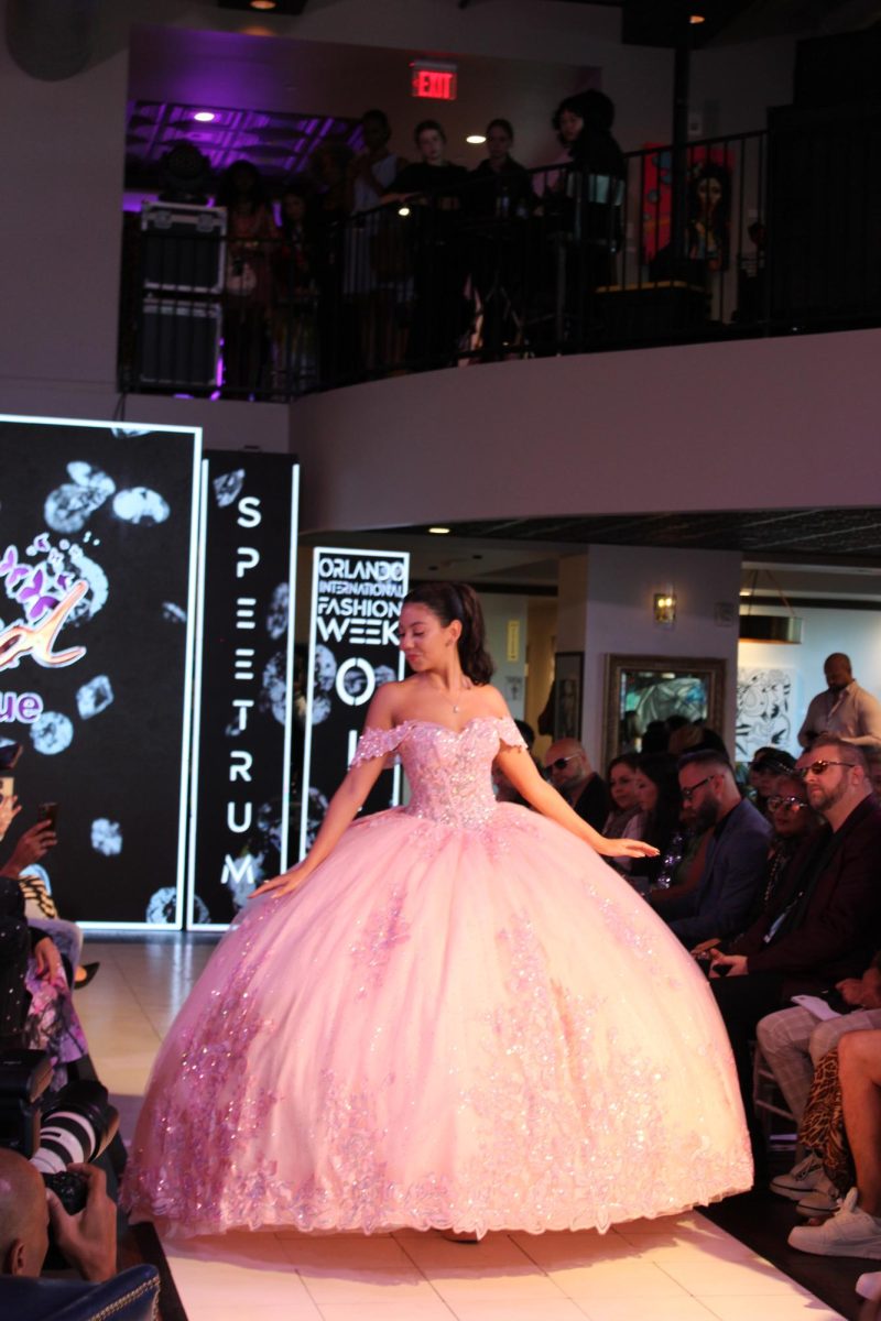 (Above) In 1996, Ingrid Tejeda and her husband, Juan Atiles, decided to move to Orlando to provide a better future for their children. Now her small business, Ingrid Tu Varedad Boutique, has been serving downtown Kissimmee for 21 years, selling clothes for all occasions but specializing in wedding and quinceñera dresses. The dress pictured above is worn by a model from Images Development, a modeling school that Tejeda manages. It is a gorgeous baby pink ball gown with layers of tulle and beautiful beading on the bodice and hem.
